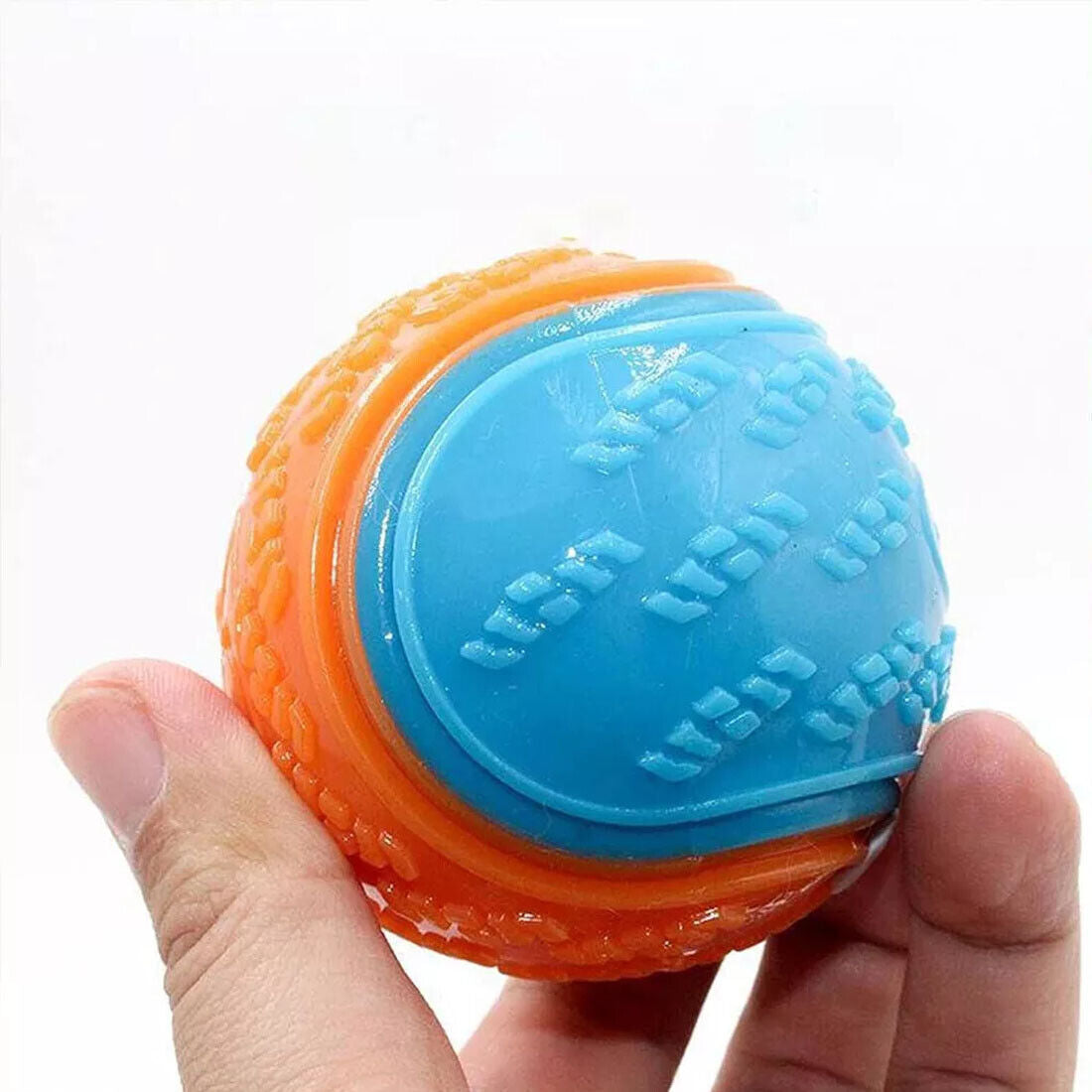 Close-up of an orange and blue durable squeaky dog ball held in hand, ideal for interactive play.